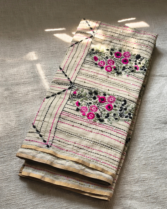 Folded fabric with floral embroidery on a textured surface